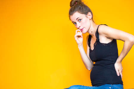 orange background girl with black top Stock Photo