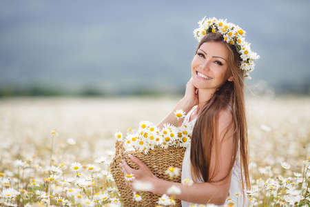 Beautiful woman enjoying daisy field