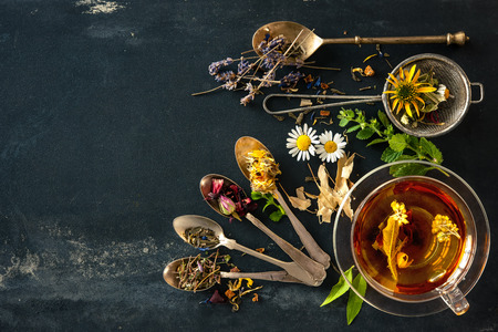 Cup of herbal tea with wild flowers and various herbs