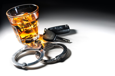 Whiskey with car keys and handcuffs concept for drinking and driving