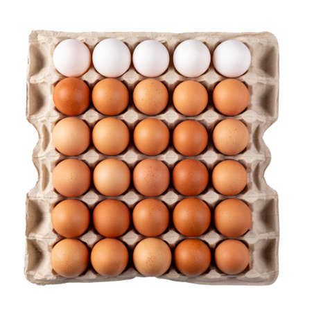 30 oeufs crus dans une boîte en carton sur fond blanc. trente œufs de poule frais. le fichier contient un chemin de détourage. vue de dessus.