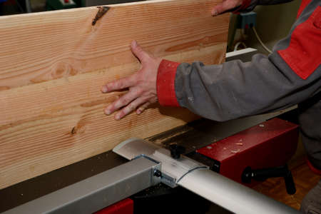 person with a planking board at the planing machine close up stock