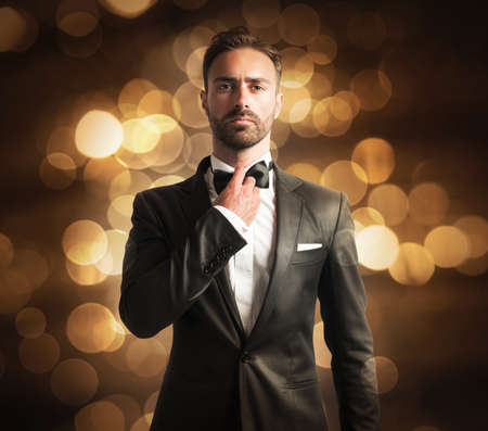 Elegant man with papillon on golden background