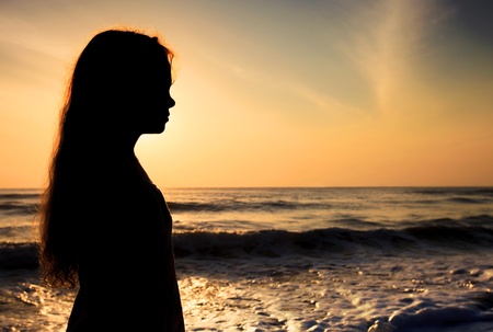 Silhouette of a sad child on the beach - 17925949