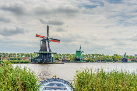 Old traditional windmill on shoreline with wind blowing grass. Includes copy space.