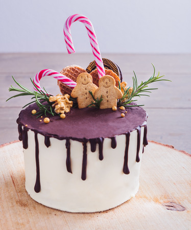 Homemade Christmas Cake Decorated With Gingerbread Men Waffles And Candy Canes On A Rustic Wood Homemade Christmas Cake Decorated With Gingerbread Men Waffles And Candy Canes On A Rustic Wood