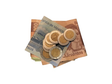 A bunch of mexican coins on top of some peso bills of 20, 100, 200 and 500 folded and grouped isolated on white background Stock Photo