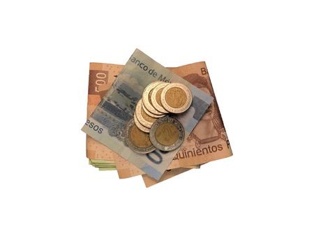 A bunch of mexican coins on top of some peso bills of 20, 100, 200 and 500 folded and grouped isolated on white background