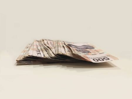 A pile of 500 pesos mexican bank notes over a white desk Stock Photo