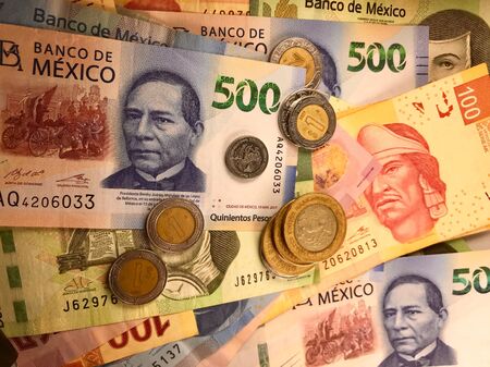 Many mexican pesos bills spread randomly over a flat surface
