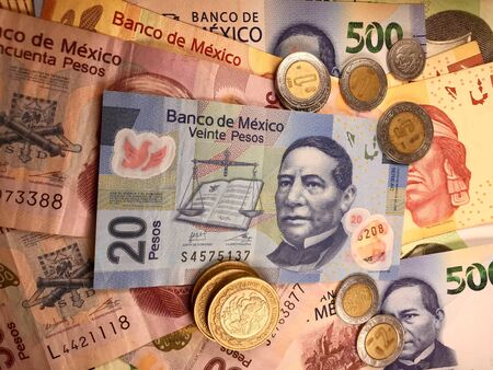 Many mexican pesos bills spread randomly over a flat surface Stock Photo