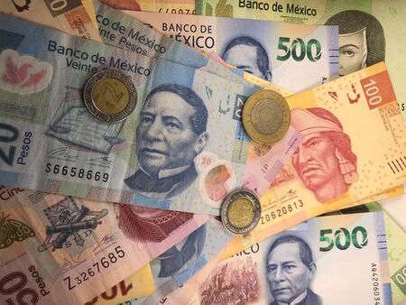 Many mexican pesos bills spread randomly over a flat surface Stock Photo