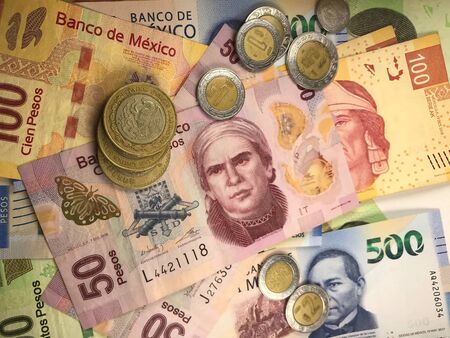 Many mexican pesos bills spread randomly over a flat surface Stock Photo