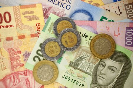 Many mexican pesos bills spread randomly over a flat surface
