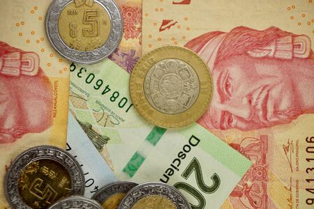Many mexican pesos bills spread randomly over a flat surface