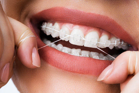 Kobiece czyszczenie aparatów dentystycznych w jamie ustnej za pomocą nici dentystycznej Zdjęcie Seryjne