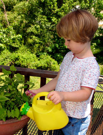 Little girl watering plants
