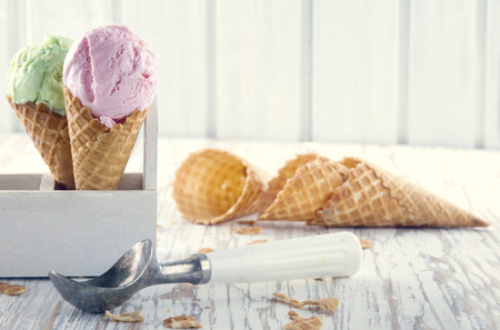 ice cream: Nón kem màu hồng và màu xanh lá cây với một muỗng kim loại cũ trên nền mộc mạc bằng gỗ