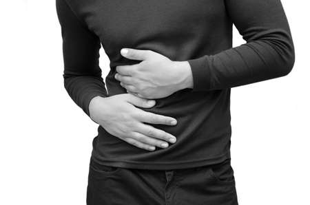 The man has a stomachache, he holds on to it. Photo horizontal black and white isolated