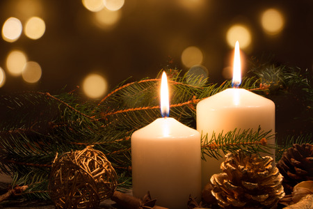 Christmas candles and ornaments over dark background with lights