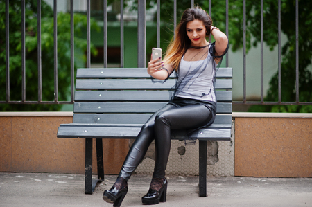ファッショナブルな女性を見て白いシャツ 黒い透明な服 革のズボンを通りのポーズと携帯電話でベンチに座っています ファッションの女の子の概念 の写真素材 画像素材 Image ファッショナブルな女性を見て白いシャツ 黒い透明な服 革のズボンを通りのポーズと携帯電話でベンチに座っています ファッションの女の子の概念 の写真素材 画像素材 Image