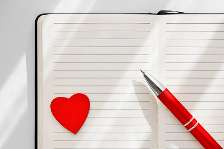 Top view notebook with red heart shape and pen on it. plan of the day, to-do list valentine day concept. leave a message. Top view notebook with red heart shape and pen on it. plan of the day, to-do list valentine day concept. leave a message.