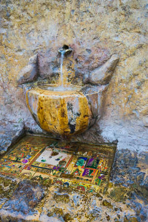 Old water fountain with decorative stone birds