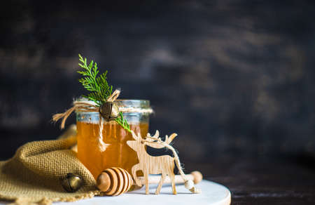 Christmas holiday concept with organic honey decorated with fir tree and jinglebells on rustic background Stock Photo
