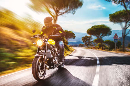 motorbike on the road riding. having fun driving the empty road on a motorcycle tour journey. copyspace for your individual text.