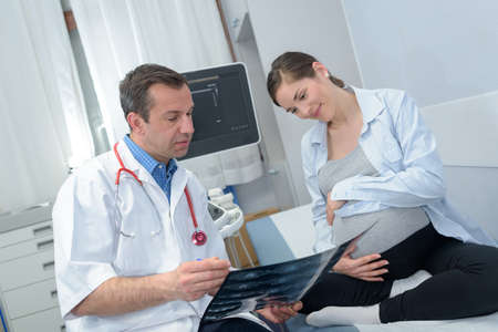 male doctor reviewing womans pregnancy scans