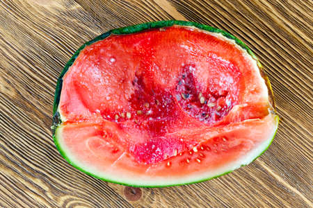 Black and white mold in a juicy red pulp rotting watermelon, close-up, top view, place photo - kitchen wooden table Stock Photo