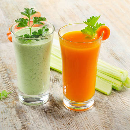 a carrot: Thức uống lành mạnh - sinh tố rau xanh và nước ép cà rốt trên một chiếc bàn gỗ tập trung chọn lọc