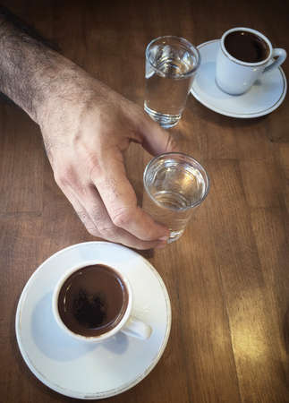 A Cup Of Turkish Coffee And Water Glass On Wooden Table Stock Photo A Cup Of Turkish Coffee And Water Glass On Wooden Table Stock Photo