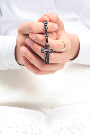 Isolated shot of an aisan woman s praying hands as holding rosary