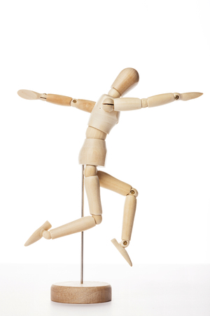 白い背景に隔離された木製のボールジョイント人形は 腕をまっすぐに横に長くジャンプする人を示しています の写真素材 画像素材 Image