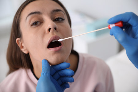 Doctor taking sample for dna test from woman in clinic Фото со стока