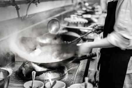 Blurred dramatic chef of a restaurant kitchen motion cooking take photo lowspeed