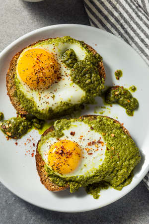 Toast aux oeufs au pesto biologique sain pour le petit-déjeuner avec du poivre