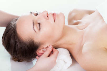 Massage: Женщина, наслаждаясь массаж уха в салоне красоты