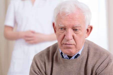 sad lonely: Sad older lonely man sitting at nursing home Stock Photo