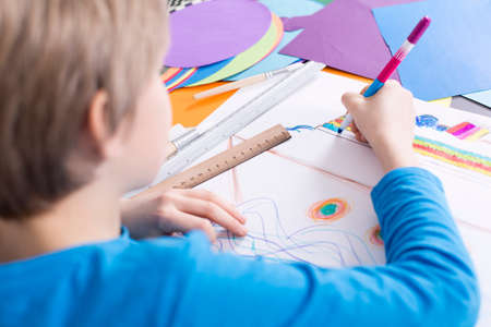 Close up of a small boy drawing a picture