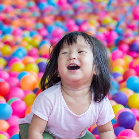 Asia niña feliz que juega con las bolas Foto de archivo - 58107645