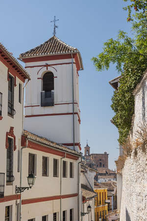 Quiet street in the lower part of the albaicin quarter with the granada cathedral in the background