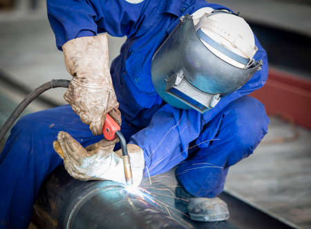 Worker with protective mask welding metal
