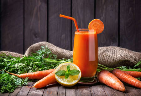 a carrot: Nước ép cà rốt với chanh và bạc hà trên nền gỗ
