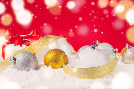 stock photo white decorative christmas gift box with ribbon and balls on snow against red festive background - Decorative Christmas Gift Boxes stock photo white decorative christmas gift box with ribbon and balls on snow against red festive background - Decorative Christmas Gift Boxes