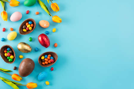 Oeufs de pâques en chocolat colorés sur fond bleu Banque d'images
