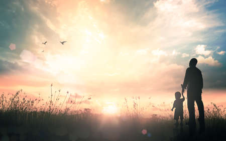 Concept de la fête des pères heureux : silhouette père et fils debout sur fond de lever de soleil pré automne Banque d'images