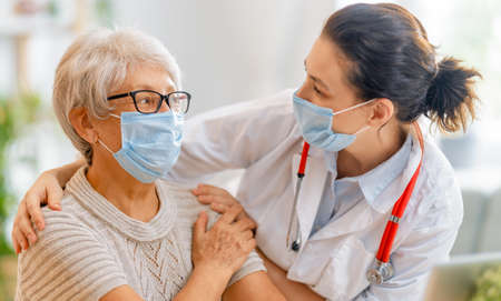 Doctor and senior woman wearing facemasks during coronavirus and flu outbreak. virus protection. covid-2019. taking on masks.