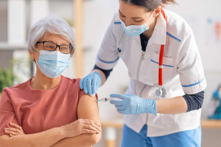 Doctor giving a senior woman a vaccination. virus protection. covid-2019.